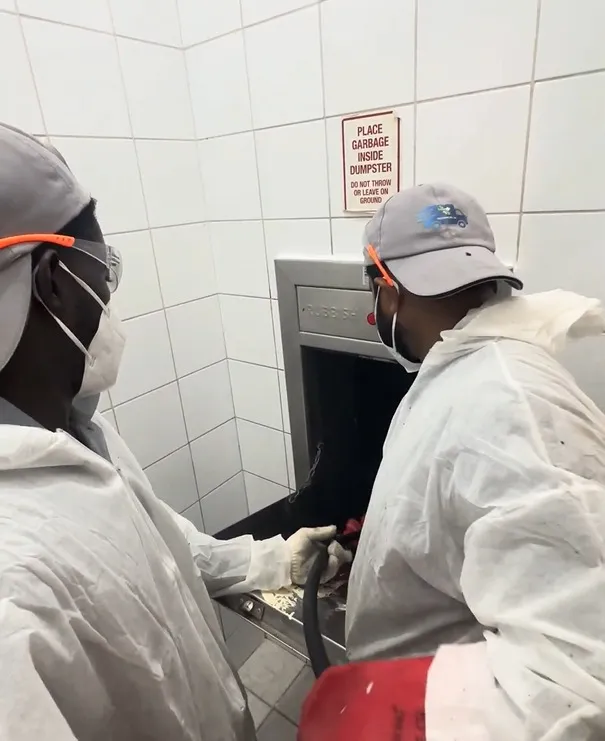 Garbage chute cleaning and maintenance work on a rooftop service area