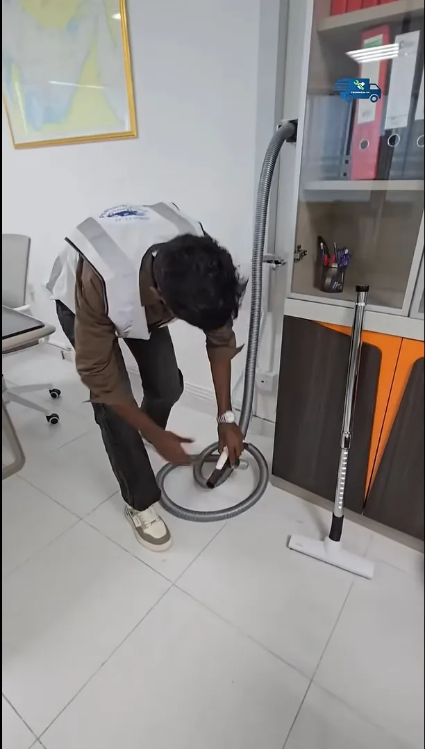 Central vacuum hose and cleaner nozzle on a wooden floor